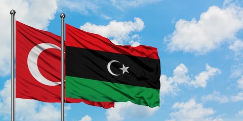 Turkey and Libya flag waving in the wind against white cloudy blue sky together. Diplomacy concept, international relations.
