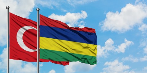 Turkey and Mauritius flag waving in the wind against white cloudy blue sky together. Diplomacy concept, international relations.