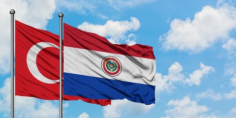 Turkey and Paraguay flag waving in the wind against white cloudy blue sky together. Diplomacy concept, international relations.