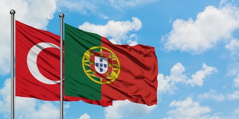 Turkey and Portugal flag waving in the wind against white cloudy blue sky together. Diplomacy concept, international relations.