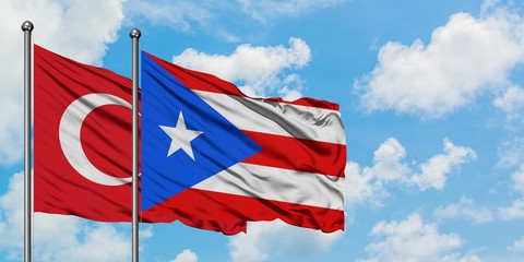 Turkey and Puerto Rico flag waving in the wind against white cloudy blue sky together. Diplomacy concept, international relations.