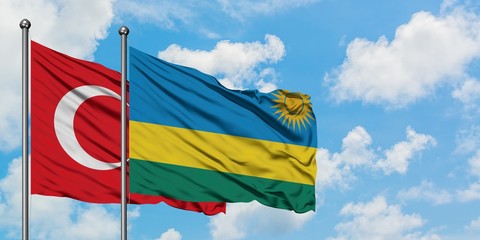 Turkey and Rwanda flag waving in the wind against white cloudy blue sky together. Diplomacy concept, international relations.