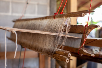 Selective focus of cotton thread on weaver machine. Thai cotton handmade. Homespun fabric process....