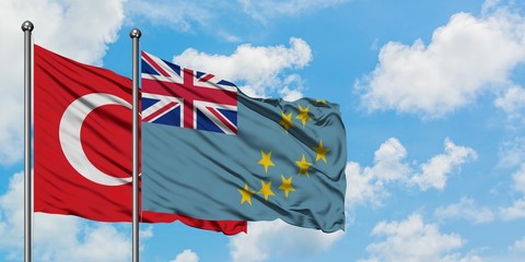 Turkey and Tuvalu flag waving in the wind against white cloudy blue sky together. Diplomacy concept, international relations.