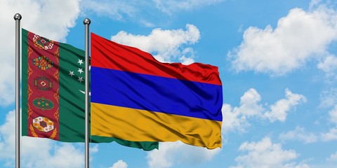 Turkmenistan and Armenia flag waving in the wind against white cloudy blue sky together. Diplomacy concept, international relations.