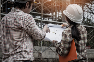 Architect and engineer discuss in building construction site.