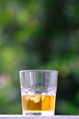 glass of whiskey and ice on wooden table