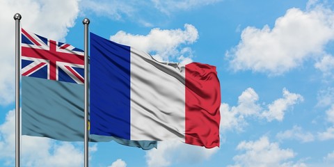 Tuvalu and France flag waving in the wind against white cloudy blue sky together. Diplomacy...