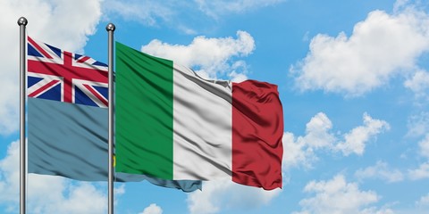 Tuvalu and Italy flag waving in the wind against white cloudy blue sky together. Diplomacy concept, international relations.
