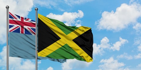 Tuvalu and Jamaica flag waving in the wind against white cloudy blue sky together. Diplomacy concept, international relations.