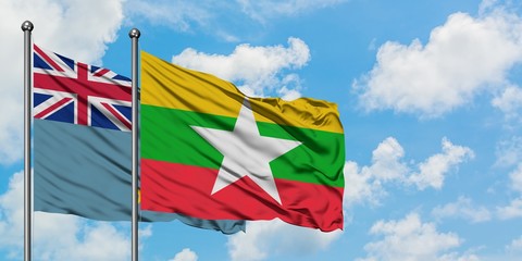 Tuvalu and Myanmar flag waving in the wind against white cloudy blue sky together. Diplomacy concept, international relations.