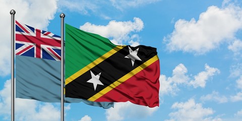 Tuvalu and Saint Kitts And Nevis flag waving in the wind against white cloudy blue sky together....