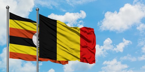 Uganda and Belgium flag waving in the wind against white cloudy blue sky together. Diplomacy concept, international relations.