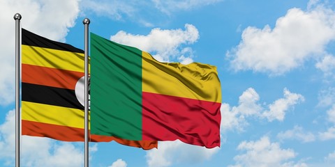 Uganda and Benin flag waving in the wind against white cloudy blue sky together. Diplomacy concept, international relations.