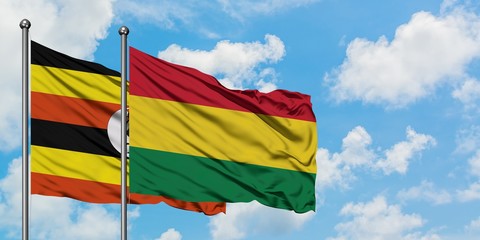 Uganda and Bolivia flag waving in the wind against white cloudy blue sky together. Diplomacy concept, international relations.