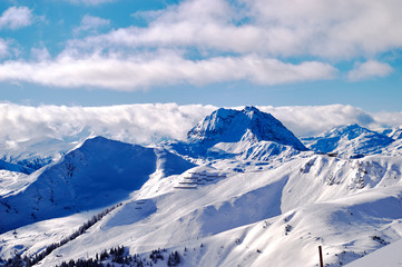 Fototapeta na wymiar panoramic view of the snowy slopes of the alpine ranges from the highest peak from under the clouds