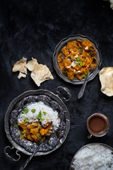 Indian style eggplant in korma sauce and rice on dark background