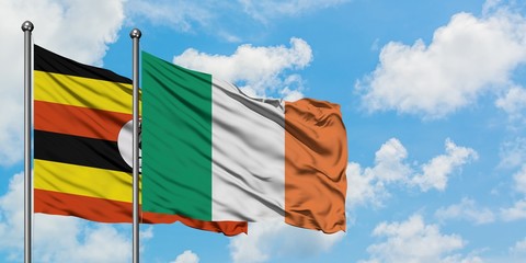 Uganda and Ireland flag waving in the wind against white cloudy blue sky together. Diplomacy concept, international relations.