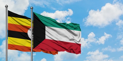 Uganda and Kuwait flag waving in the wind against white cloudy blue sky together. Diplomacy concept, international relations.
