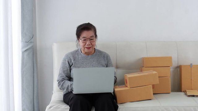 Asian senior woman in drinking coffee in living room
