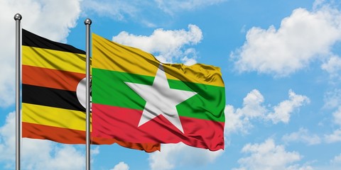 Uganda and Myanmar flag waving in the wind against white cloudy blue sky together. Diplomacy concept, international relations.