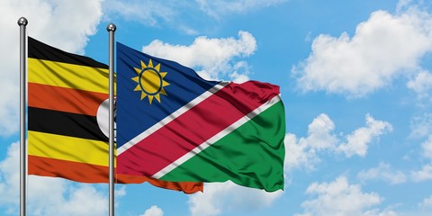 Uganda and Namibia flag waving in the wind against white cloudy blue sky together. Diplomacy concept, international relations.