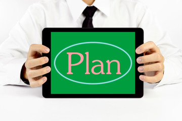 Businessman holding a tablet with pink word Plan