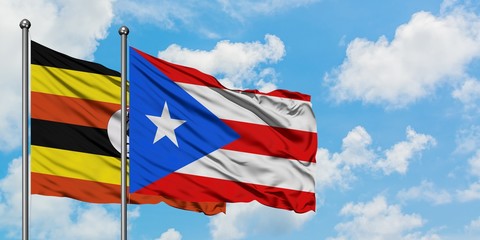 Fototapeta premium Uganda and Puerto Rico flag waving in the wind against white cloudy blue sky together. Diplomacy concept, international relations.