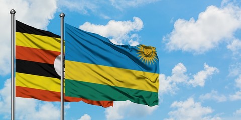 Uganda and Rwanda flag waving in the wind against white cloudy blue sky together. Diplomacy concept, international relations.