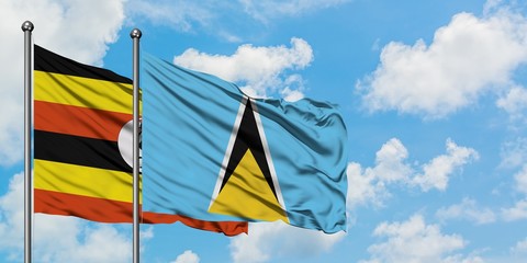 Uganda and Saint Lucia flag waving in the wind against white cloudy blue sky together. Diplomacy concept, international relations.