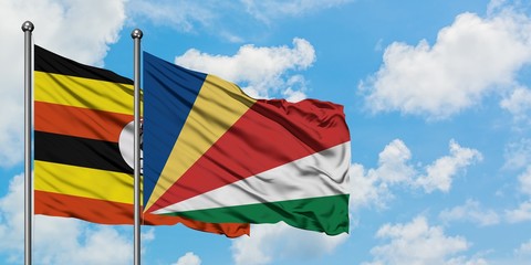 Uganda and Seychelles flag waving in the wind against white cloudy blue sky together. Diplomacy concept, international relations.