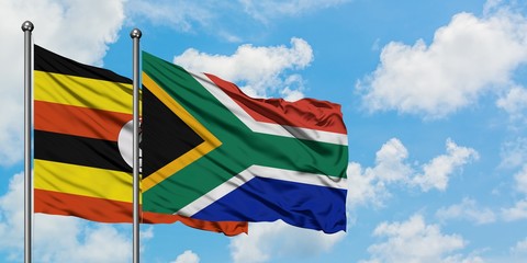 Uganda and South Africa flag waving in the wind against white cloudy blue sky together. Diplomacy concept, international relations.