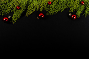 Christmas composition. Girlanda with red Christmas ornaments on black background. Christmas, winter, new year concept. Flat lay, top view, copy space. © Julio Ricco