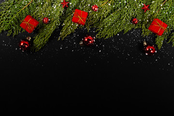 Christmas composition. Girlanda with red Christmas ornaments, gifts and snow on black background. Christmas, winter, new year concept. Flat lay, top view, copy space. © Julio Ricco