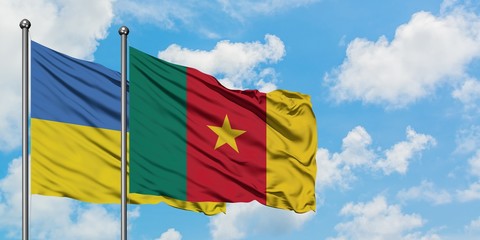 Ukraine and Cameroon flag waving in the wind against white cloudy blue sky together. Diplomacy concept, international relations.