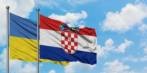 Ukraine and Croatia flag waving in the wind against white cloudy blue sky together. Diplomacy concept, international relations.