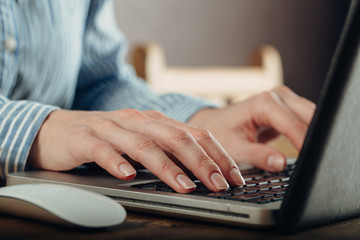 Woman working at home office hand on keyboard close up
