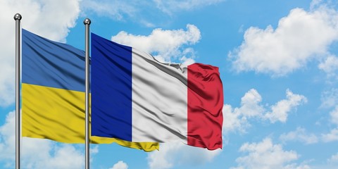 Ukraine and France flag waving in the wind against white cloudy blue sky together. Diplomacy concept, international relations.