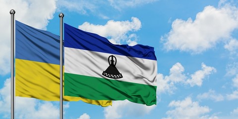 Ukraine and Lesotho flag waving in the wind against white cloudy blue sky together. Diplomacy concept, international relations.