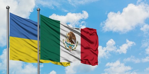 Ukraine and Mexico flag waving in the wind against white cloudy blue sky together. Diplomacy concept, international relations.