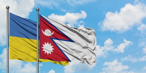 Ukraine and Nepal flag waving in the wind against white cloudy blue sky together. Diplomacy concept, international relations.