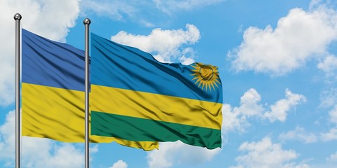 Ukraine and Rwanda flag waving in the wind against white cloudy blue sky together. Diplomacy concept, international relations.