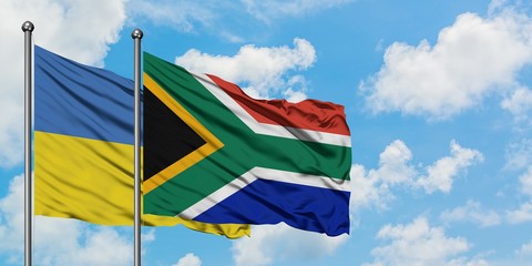 Ukraine and South Africa flag waving in the wind against white cloudy blue sky together. Diplomacy concept, international relations.