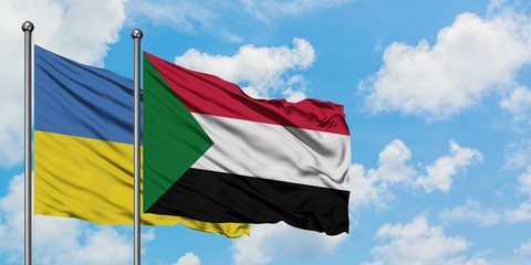 Ukraine and Sudan flag waving in the wind against white cloudy blue sky together. Diplomacy concept, international relations.