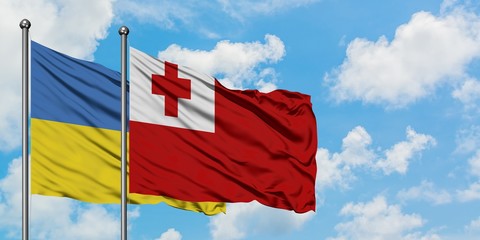 Ukraine and Tonga flag waving in the wind against white cloudy blue sky together. Diplomacy concept, international relations.