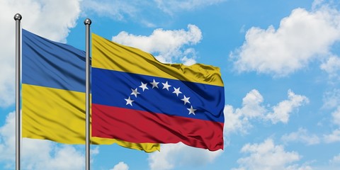 Ukraine and Venezuela flag waving in the wind against white cloudy blue sky together. Diplomacy concept, international relations.