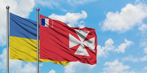 Ukraine and Wallis And Futuna flag waving in the wind against white cloudy blue sky together. Diplomacy concept, international relations.
