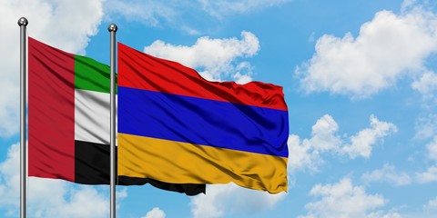 United Arab Emirates and Armenia flag waving in the wind against white cloudy blue sky together. Diplomacy concept, international relations.