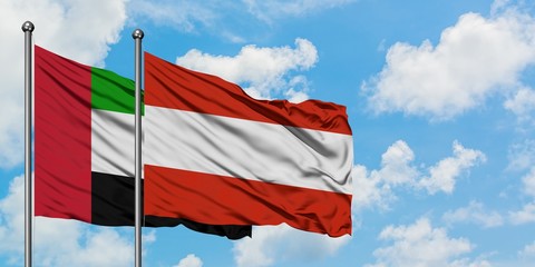 United Arab Emirates and Austria flag waving in the wind against white cloudy blue sky together. Diplomacy concept, international relations.