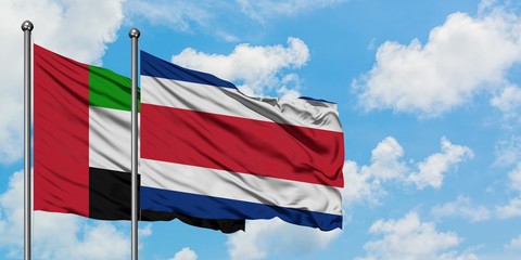 United Arab Emirates and Costa Rica flag waving in the wind against white cloudy blue sky together. Diplomacy concept, international relations.